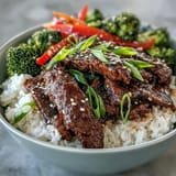 Teriyaki Beef Bowl garnished with fresh green onions and toasted sesame seeds for extra texture.