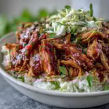 Shredded pork bowl topped with creamy coleslaw and green onions, served ready to eat