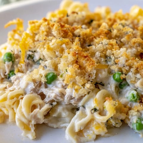 Family-style baked Tuna Casserole fresh from the oven, bubbling with flaky tuna, peas, and noodles in a creamy sauce.