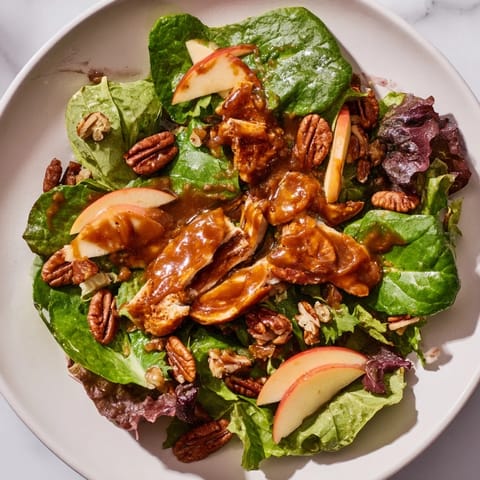 Savory-sweet Caramel Apple Chicken Salad topped with crumbled feta, dried cranberries, and a glossy caramel-pecan dressing.