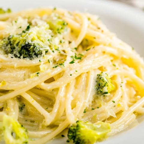Serving of One-Pot Lemon Broccoli Pasta garnished with grated Parmesan, black pepper, and chopped basil on a plate.