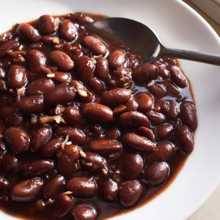 Sweet-savory baked beans garnished with fresh parsley at a sunny barbecue.