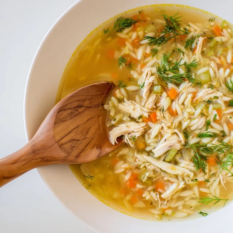 Hearty Chicken Lemon Orzo Soup simmering with tender chicken, carrots, celery, and delicate pasta.  