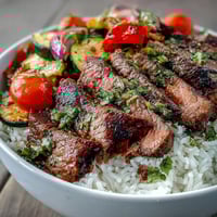 Juicy grilled steak slices and colorful roasted vegetables top fluffy rice in this easy Sheet Pan Steak and Veggie Bowl.